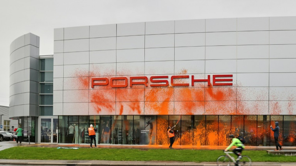 Cuatro activistas clim&aacute;ticos roc&iacute;an un concesionario Porsche con pintura naranja en Suiza